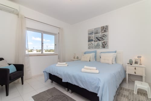 Bright bedroom at MarVillas Rentals in Lagoa with blue bedding, twin beds, modern furnishings and window view
