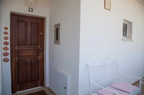 Bedroom at Casa Branco, MarVillas Rentals in Lagoa, with white metal bed frame and wooden door