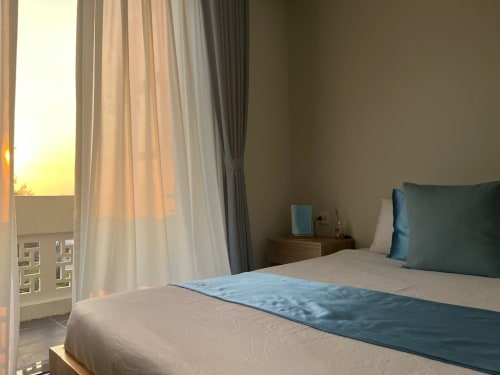 Chambre vue mer de l'hôtel Cybade à Phu Quoc avec lit queen-size, accents bleus et vue coucher de soleil sur l'océan