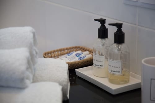 Balcão do banheiro em MarVillas Rentals em Lagoa com produtos de jasmin, toalhas e cesto trançado