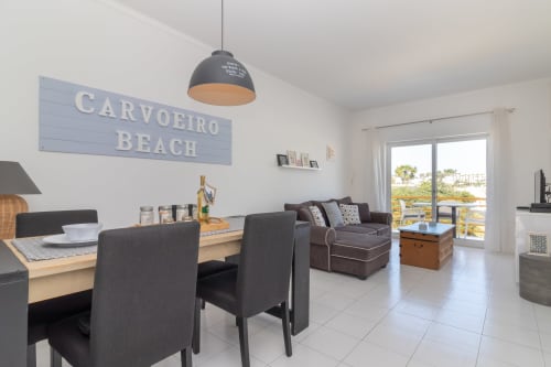 Área de estar moderna em conceito aberto em MarVillas Carvoeiro Beach, Lagoa, com mesa de jantar, sofá marrom e vistas para o oceano