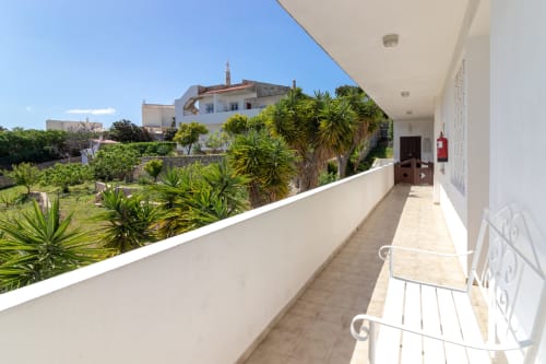 Varanda à beira-mar em MarVillas Rentals em Lagoa com vistas de palmeiras e arquitetura mediterrânea