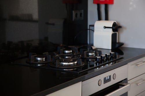 Fogão a gás moderno preto com forno branco na cozinha de MarVillas Rentals, Lagoa Portugal