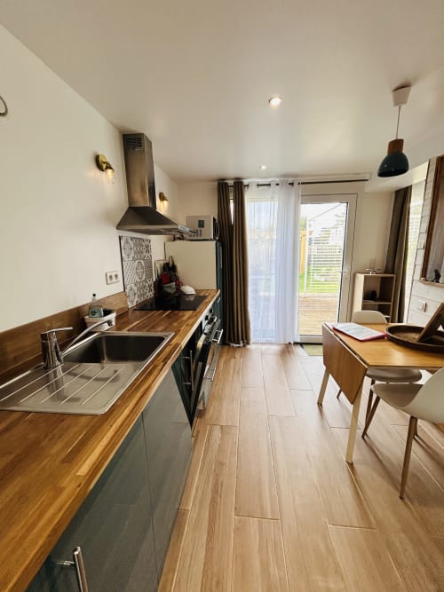 Modern kitchen and dining area in La Bounty cottage at La Villa Plein Vent, Barneville-Carteret with wooden counters and