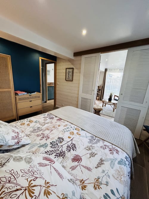 Spacious bedroom with double bed, wooden furnishings, and garden view at La Bounty cottage, Barneville-Carteret