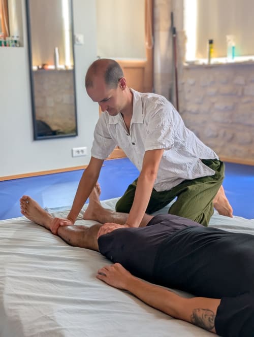Massage therapist performing therapeutic treatment on client at Old Presbytery Guest House wellness center in