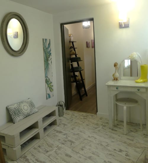 Chambre moderne et lumineuse à La Cour Des Saligues à Riscle, avec coiffeuse blanche, miroirs et décoration botanique