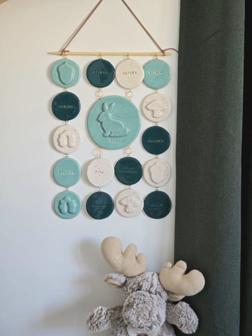 Calendrier zodiaque en céramique suspendu au mur du Bois De Luna BnB à Cunlhat, France, avec une peluche d'orignal