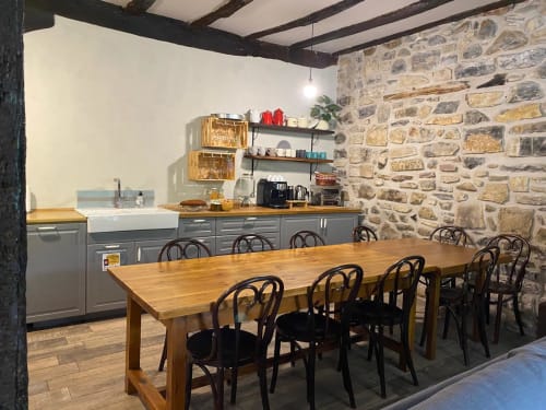 Amplio comedor en la posada Casa Rural Donamariako Benta en Donamaria con mesa de madera, muros de piedra y cocina moderna