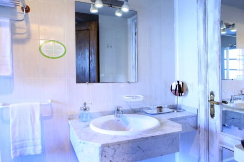 Baño moderno con tocador de mármol, lavamanos redondo blanco y espejo en la villa Casa Rural Donamariako Benta en Donamaria, España