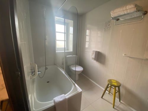 Baño moderno con ducha abierta, inodoro y toallero en la posada Casa Rural Donamariako Benta de Donamaria, España