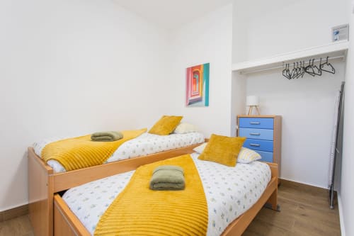 Dos camas individuales con ropa de cama amarilla en dormitorio luminoso de Haus Holiday Homes, Los Alcázares