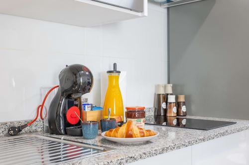 Encimera de cocina con cafetera Nespresso, cruasanes, zumo de naranja y café en Casa Libertenio, Los Alcázares