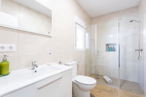 Baño moderno con lavabo blanco, inodoro y ducha de paso en Casa Libertenio, Los Alcázares