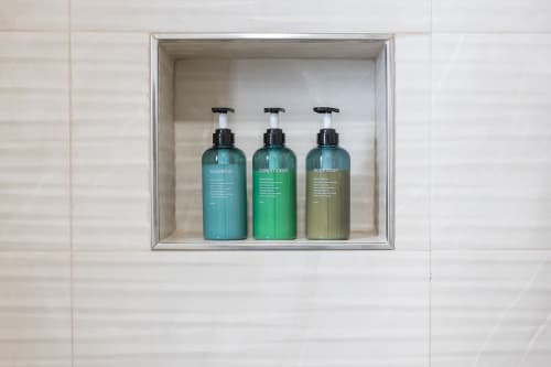 Tres botellas dosificadoras de champú, acondicionador y jabón corporal en estantería del baño de Haus Holiday Homes, San Pedro del Pinatar