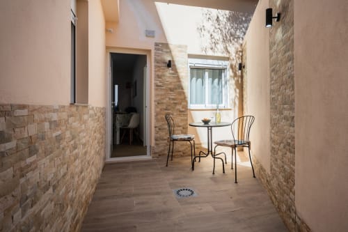 Luminoso patio en Haus Holiday Homes de Los Alcázares con muros de ladrillo, mesa de comedor y sillas