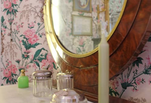 Elegant bathroom vanity with gilt mirror and floral wallpaper at Domaine de Bort, a historic French guesthouse near Limoges