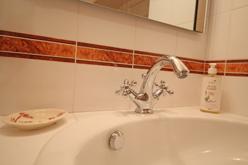 Elegant bathroom sink with chrome faucet and decorative soap dish at Domaine de Bort near Limoges