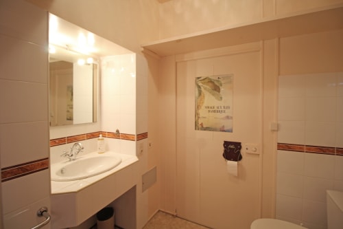 Bright bathroom in La Chambre des Isles at Domaine de Bort near Limoges with sink, mirror, and shower area