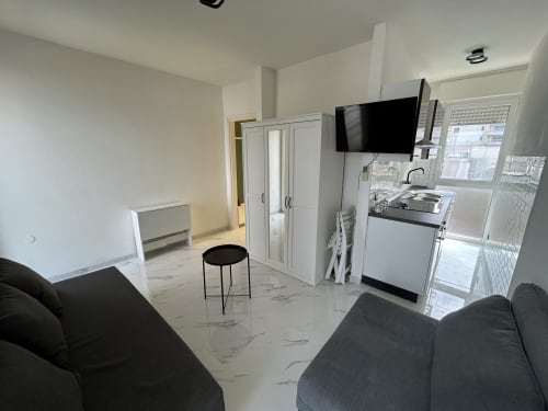 Cucina e living in stile loft moderno all'hotel Anthea di Lignano Sabbiadoro con arredamenti bianchi e TV schermo piatto