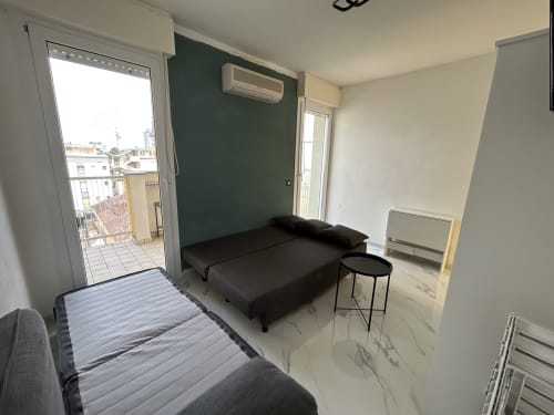 Appartamento Loft Harmonia a Lignano Sabbiadoro con divano scuro, accesso al balcone e vista sulla città