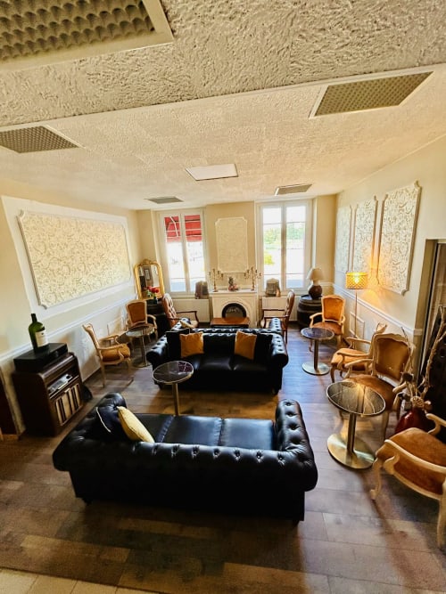 Salon de l'Hôtel de Champagne à Saint-Dizier avec canapés en cuir noir, fauteuils beige et décoration élégante