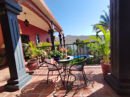 Terraza con asientos en la villa Casa Punta Perula en Punta Perula, México, con vistas a las montañas y plantas de palma