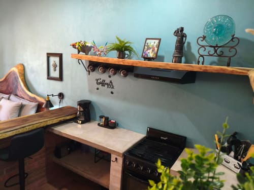 Acogedora habitación de villa en Casa Punta Perula con paredes turquesas, escritorio de madera, estante de barra de café y decoración con vista al jardín.
