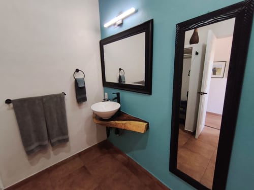 Baño moderno en villa Villita Oaxaca de Casa Punta Perula, con paredes turquesas, lavamanos tipo vasija y espejo con marco negro
