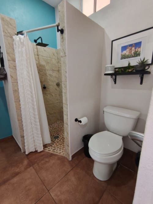 Baño moderno en villa Villita Oaxaca del Hotel Boutique Casa Punta Perula, con ducha walk-in, inodoro y tonos turquesas