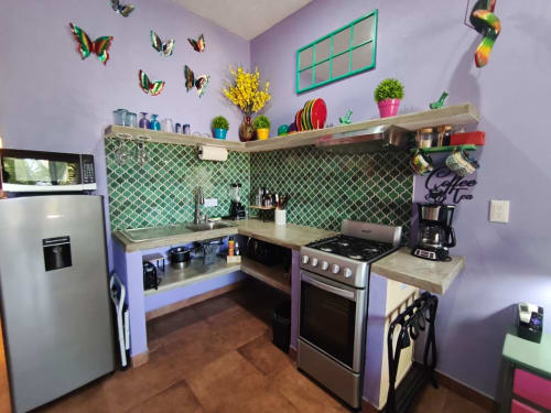 Cocina colorida en la villa Villita Guanajuato de Casa Punta Perula, con paredes púrpura y azulejos verdes