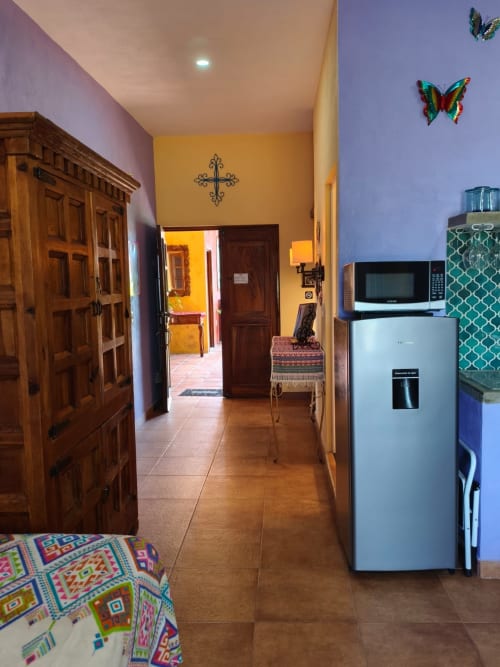 Pasillo de cocina de la villa Casa Punta Perula con refrigerador, microondas, decoración colorida y puertas de madera