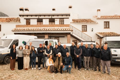 Team photo at Escanda Building Solutions hotel courtyard with vehicles and colonial architecture in Spain