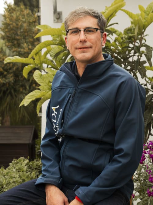 Man in navy jacket posing with cacti at Escanda Building Solutions hotel in Spain