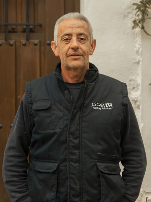 Professional staff member wearing Escanda Building Solutions black work jacket at Spanish hotel