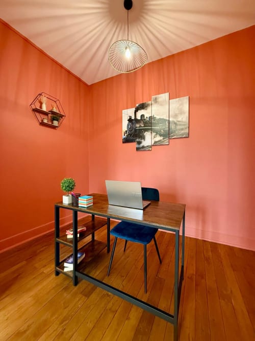 Espace de travail contemporain dans l'appartement haussmannien Le 48 à Roanne, aux murs orange, avec bureau en bois et ordinateur portable