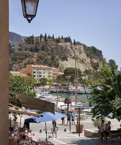 Vue du port de Maison Calc à Cassis avec bateaux, café en bord de mer et villa d'architecture collinaire