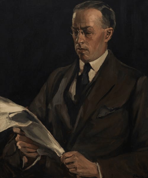 Formal portrait of man in dark suit holding papers at Madelines Accommodation hotel in Wicklow, Ireland