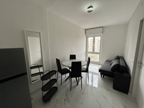 Moderna zona living in loft con tavolo da pranzo, sedie nere, divano e vista sulla città presso l'Anthea Hotel, Lignano Sabbiadoro