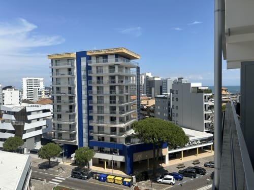 Hotel Anthea a Lignano Sabbiadoro con vista mare, moderno edificio bianco e blu affacciato sulla spiaggia