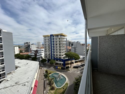 Balcone dell'Anthea Hotel con vista su Lignano Sabbiadoro, piscina e edificio con accenti blu