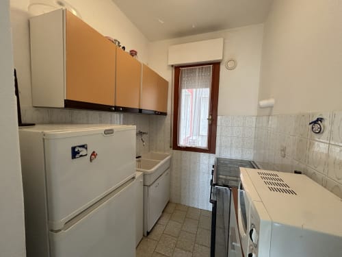 Compact kitchen in Anthea Comfort Apartment, Lignano Sabbiadoro with appliances and beige tile
