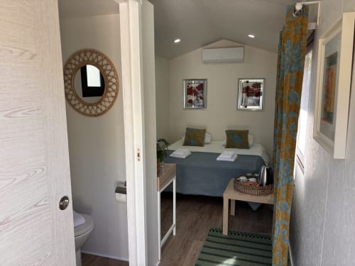 Interior aconchegante da cabana de glamping Arrabia Guest Houses com cama de casal, casa de banho e comodidades modernas em Castelo de Paiva