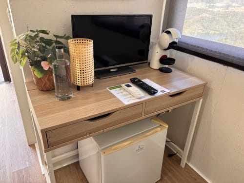 Aconchegante quarto em Arrabia Guest Houses com escrivaninha de madeira, TV, planta em vaso e cafeteira com vista para o rio