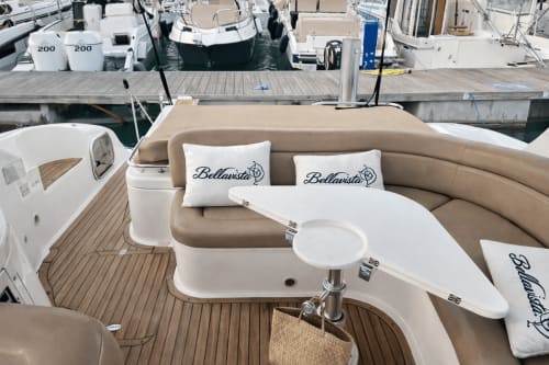 Lounge-Bereich auf dem Bootsdeck von Bellavista in Cefalù mit beigefarbenen Sitzplätzen, weißen Kissen und möbliertem Außenbereich