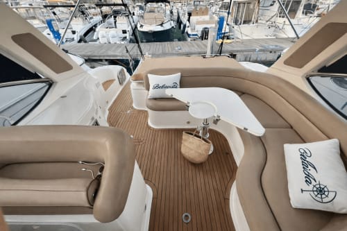 Luxus-Yachtlounge mit beigefarbigen Sitzplätzen, Holzdeck und Bellavista-Branding in Cefalù, Italien