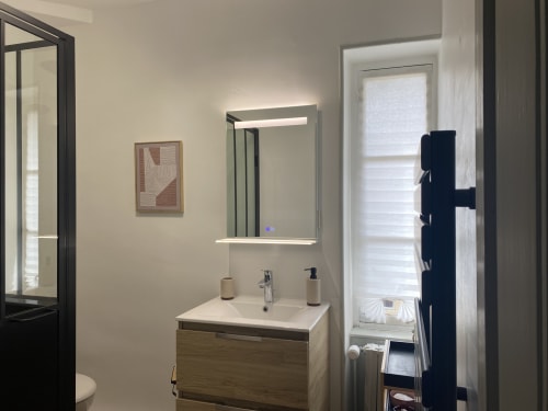 Modern bathroom in Clos Ceres B&B Burgundy with lit mirror, wooden vanity, and shower access