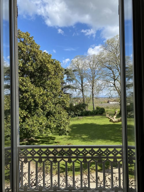 Verdant garden view from Clos Ceres bedroom in Burgundy with mature trees and manicured lawn