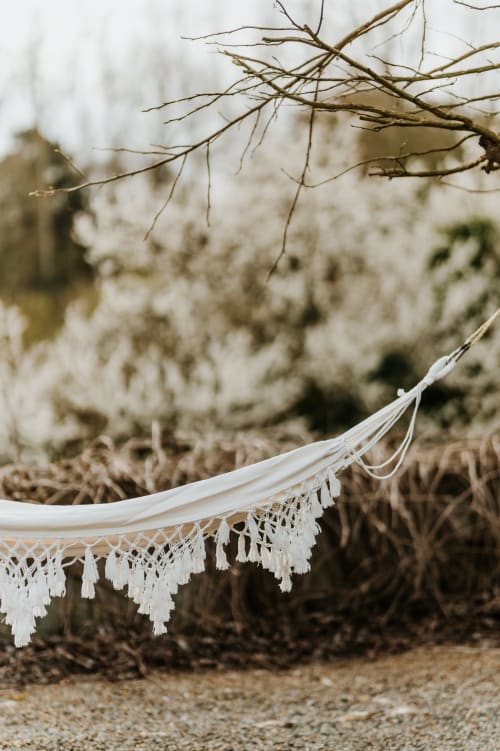 Hamac blanc à dentelle suspendu aux branches nues aux Granges De Pil Bara, Langoat