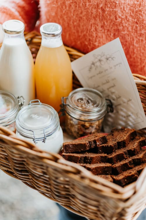 Panier de petit-déjeuner aux Granges De Pil Bara avec lait frais, jus, pain, pots et pâtisseries à Langoat